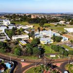 Vista aérea de um campus universitário brasileiro, com edifícios acadêmicos cercados por áreas verdes.